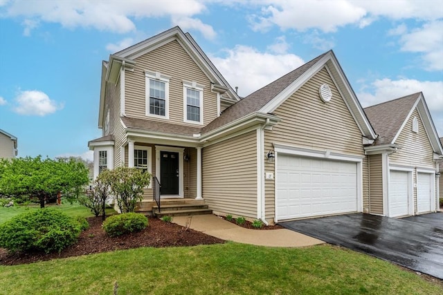 traditional home with a garage, a shingled roof, driveway, and a front yard