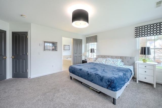 bedroom with carpet floors, baseboards, ensuite bathroom, and visible vents