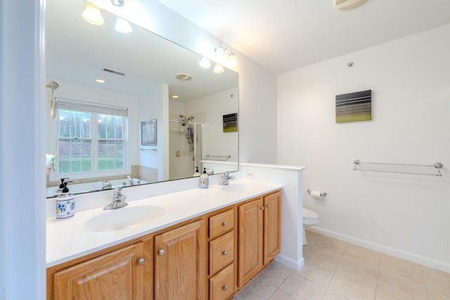 full bathroom with double vanity, a shower stall, a sink, tile patterned floors, and toilet