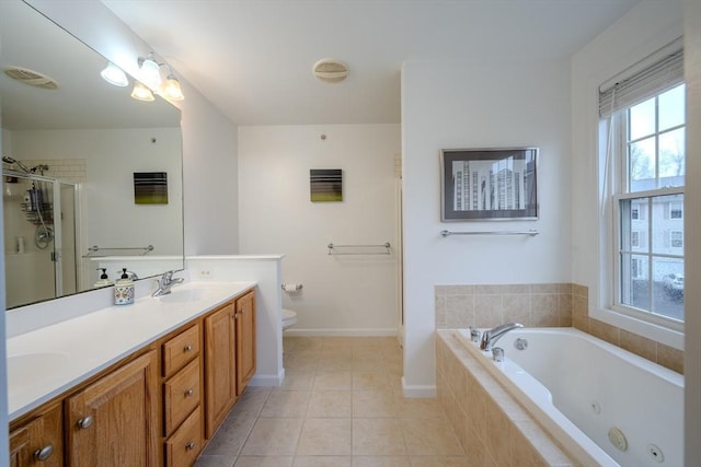 bathroom featuring a jetted tub, double vanity, tile patterned flooring, a sink, and toilet
