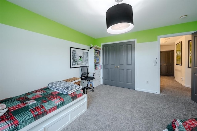 bedroom featuring baseboards, carpet, and a closet