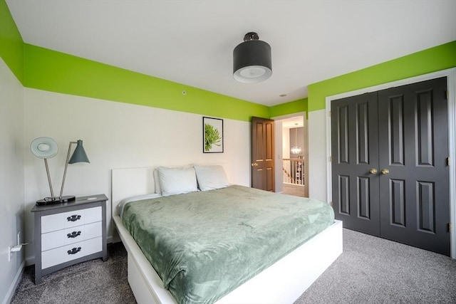 bedroom with baseboards, a closet, and dark carpet