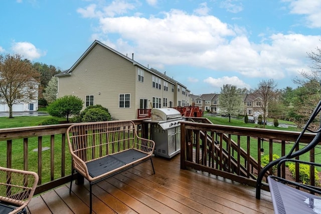 wooden deck with a residential view, a yard, and a grill