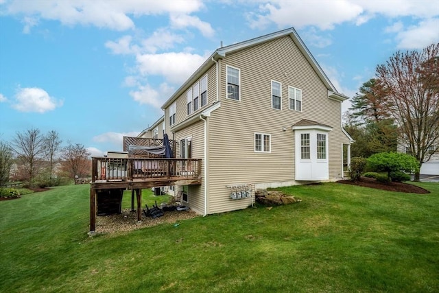 back of property with a lawn and a deck
