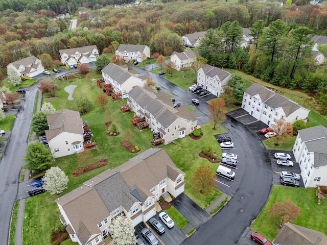 drone / aerial view featuring a residential view and a forest view