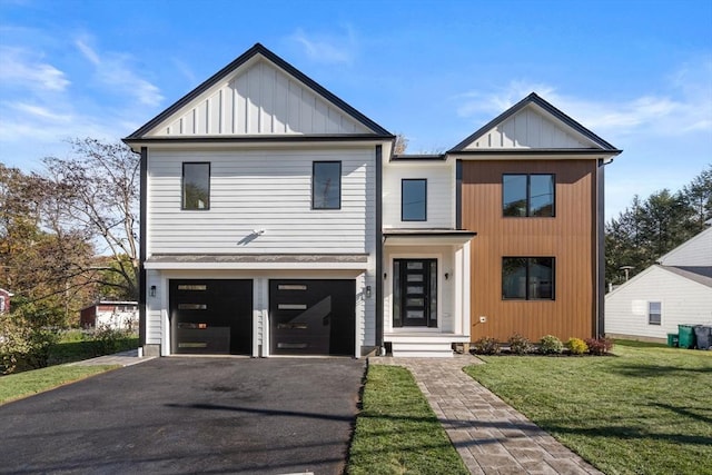 modern inspired farmhouse featuring a front lawn and a garage