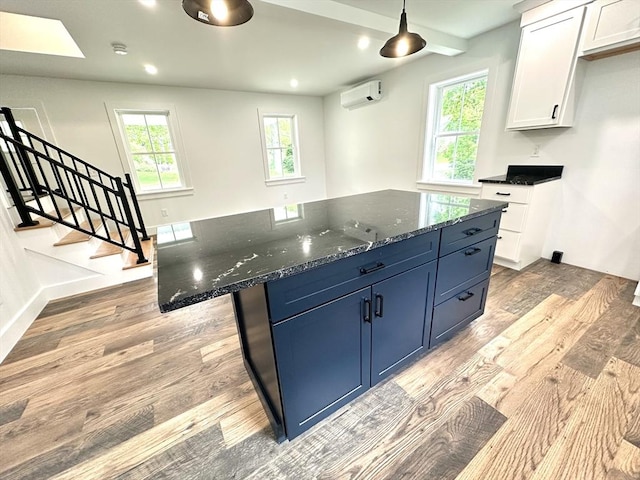 90 Bald Mountain Rd, Bernardston, MA 01337 - kitchen with a wall unit AC, light wood finished floors, white cabinetry, a kitchen island, and recessed lighting