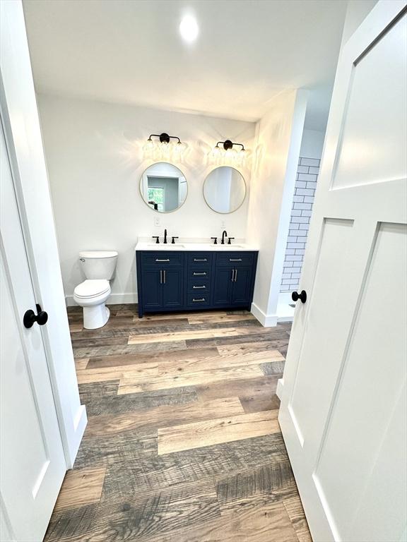 90 Bald Mountain Rd, Bernardston, MA 01337 - full bathroom featuring double vanity, toilet, wood finished floors, a shower, and baseboards