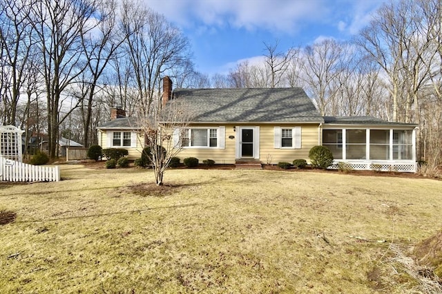 view of front of house with a front lawn and a sunroom