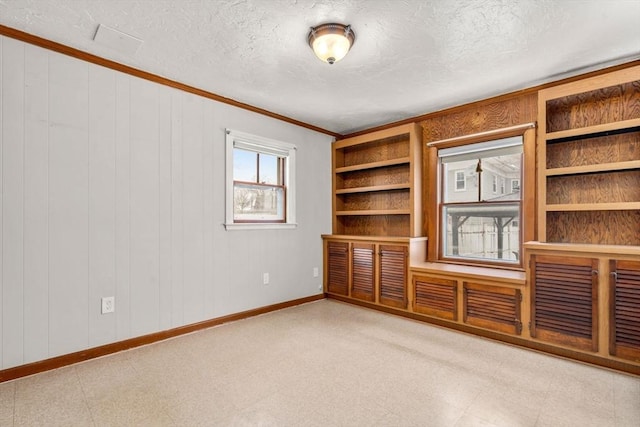 interior space featuring a textured ceiling, baseboards, and tile patterned floors