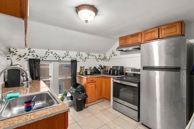 kitchen featuring light tile patterned floors, under cabinet range hood, a sink, light countertops, and appliances with stainless steel finishes