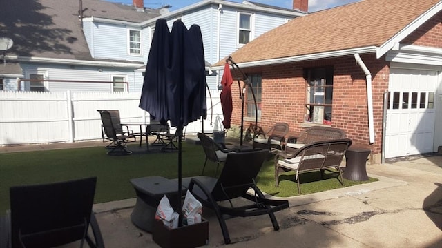 view of patio / terrace with a garage and fence