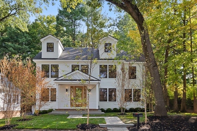 new england style home with a front lawn