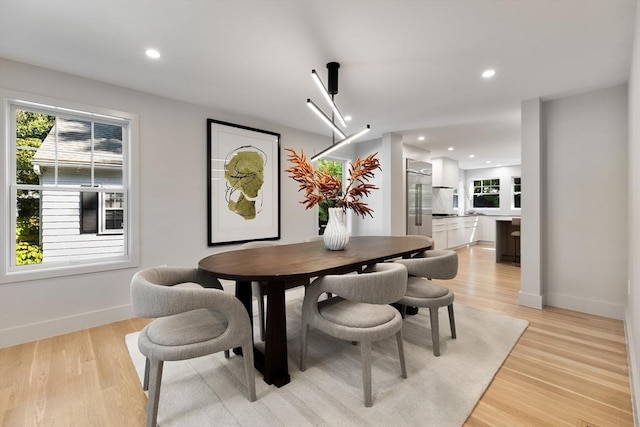 dining room featuring light wood-type flooring and an inviting chandelier