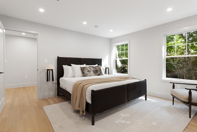 bedroom featuring multiple windows and light hardwood / wood-style flooring