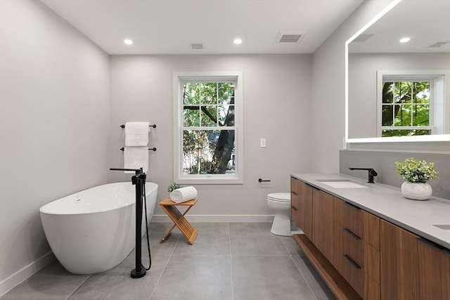 bathroom featuring vanity, toilet, plenty of natural light, and a tub