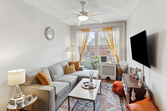 living area with ceiling fan, wood finished floors, and radiator heating unit