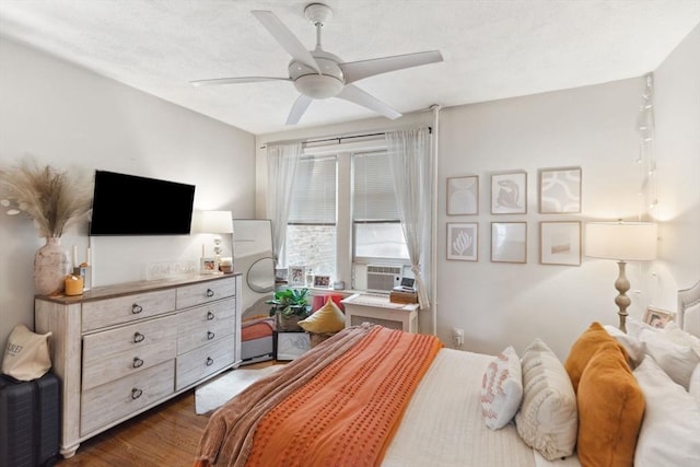 bedroom featuring a textured ceiling, a ceiling fan, and wood finished floors