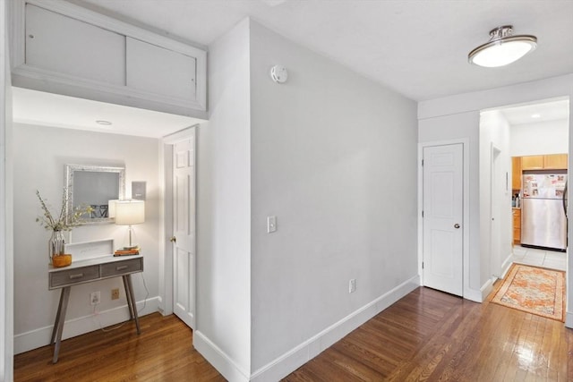 hallway with baseboards and wood-type flooring