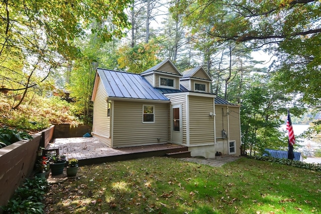 rear view of property featuring a yard and a deck