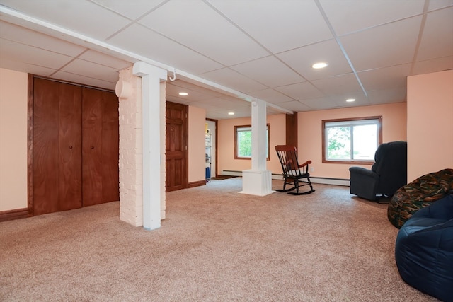 unfurnished living room featuring a paneled ceiling, baseboard heating, and carpet flooring