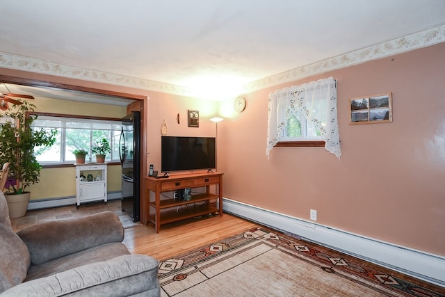 living room with baseboard heating and wood-type flooring