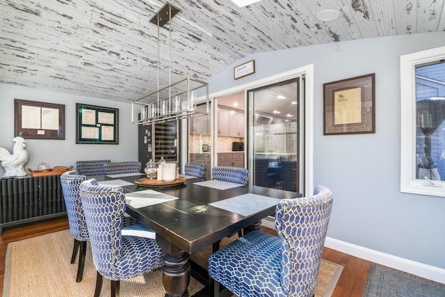 dining room with dark hardwood / wood-style floors and vaulted ceiling