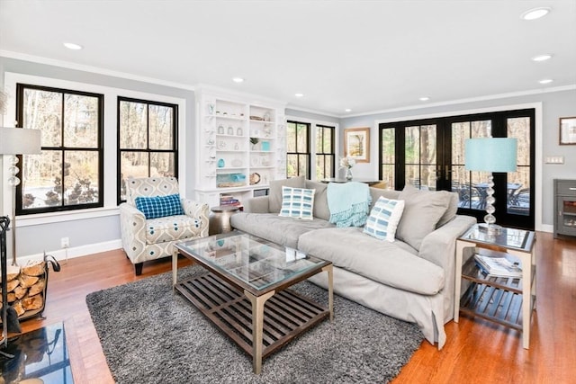 living room with hardwood / wood-style floors, crown molding, and french doors