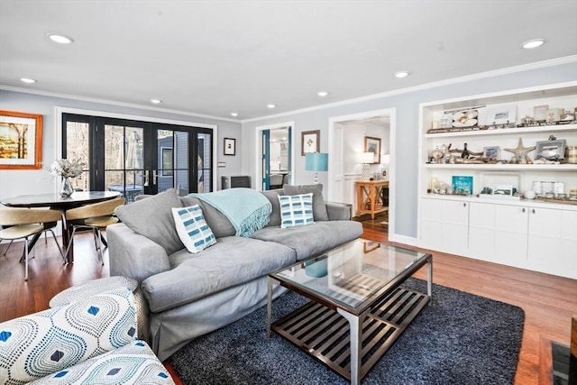 living room with hardwood / wood-style floors, ornamental molding, and french doors