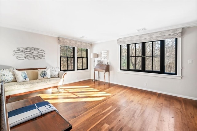 living area with hardwood / wood-style floors and crown molding