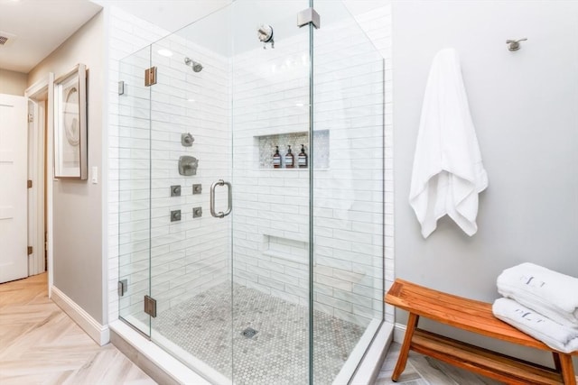 bathroom with a shower with door and parquet floors