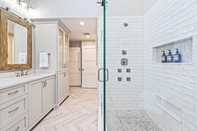 bathroom featuring vanity, parquet floors, and a shower with door