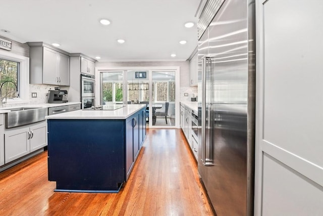 kitchen featuring a center island, stainless steel appliances, light hardwood / wood-style flooring, backsplash, and crown molding