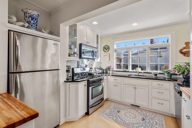 kitchen with crown molding, appliances with stainless steel finishes, sink, and white cabinets