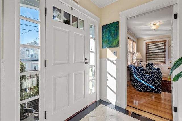 foyer with ornamental molding and tile patterned floors