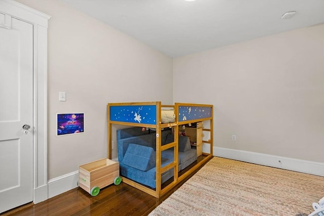 bedroom with baseboards and wood finished floors