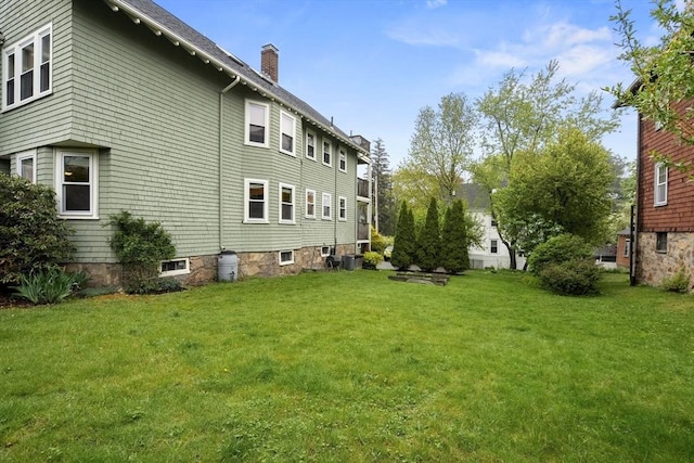 view of home's exterior with a yard, a chimney, and central AC unit
