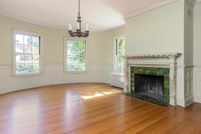 87 Hammond St, Newton, MA 02467 - unfurnished living room featuring radiator, a chandelier, wood finished floors, wainscoting, and crown molding