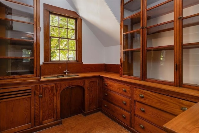 87 Hammond St, Newton, MA 02467 - kitchen featuring a sink, lofted ceiling, brown cabinets, and light countertops