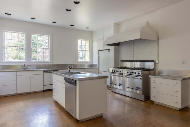 kitchen with a wealth of natural light, sink, white cabinetry, and stainless steel appliances