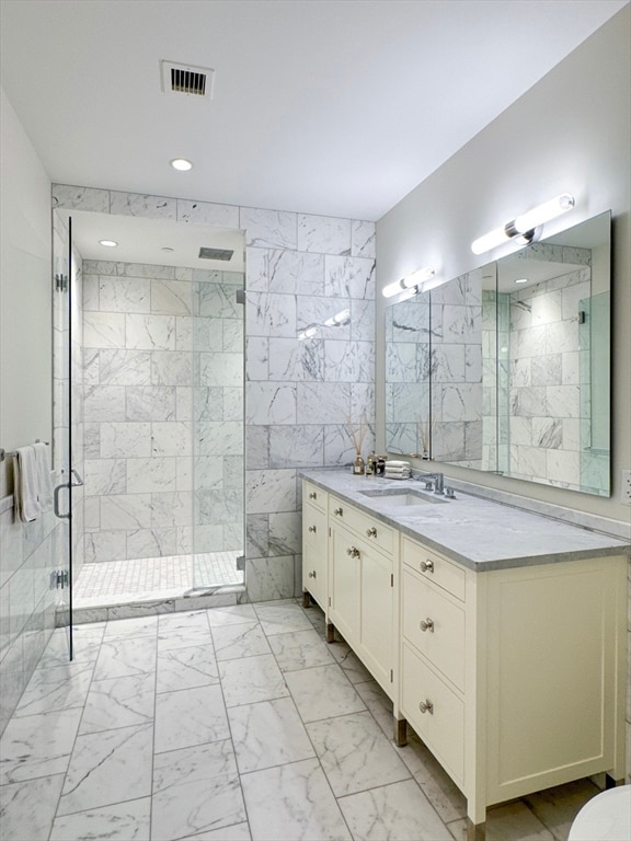 bathroom with vanity, tile walls, and an enclosed shower