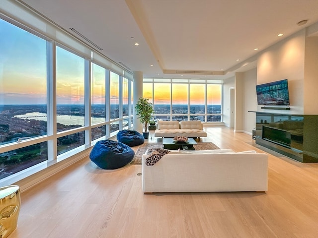 living room featuring a wall of windows and light hardwood / wood-style floors