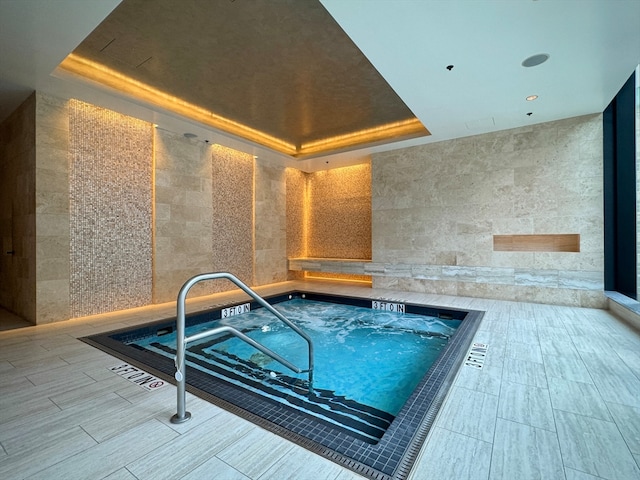 view of swimming pool featuring an indoor hot tub