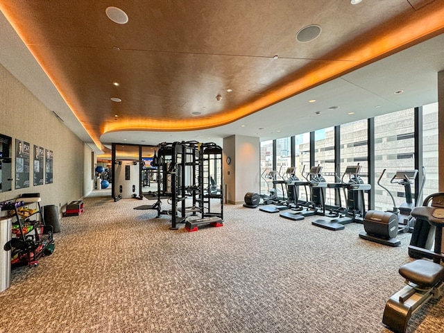 exercise room with expansive windows and carpet floors