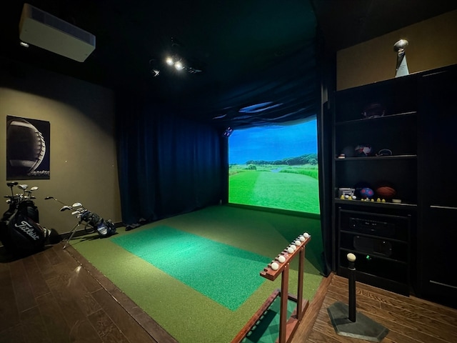 recreation room with hardwood / wood-style flooring and golf simulator