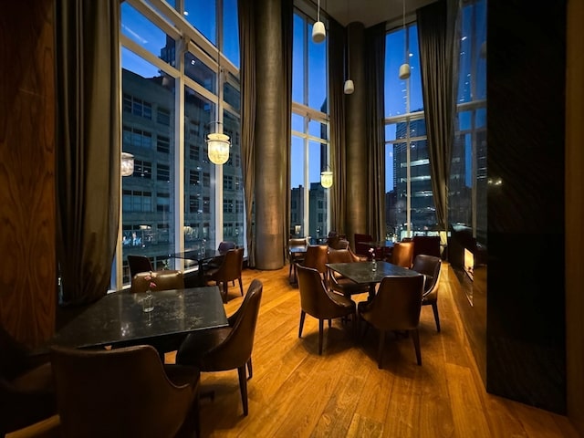 dining space with hardwood / wood-style floors and a wall of windows