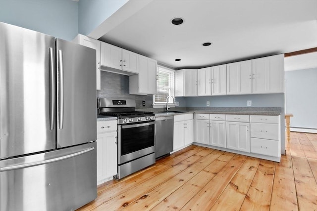 80 Lennox Rd Unit 1, Nahant, MA 01908 - kitchen with appliances with stainless steel finishes, a sink, white cabinetry, light wood-style flooring, and baseboard heating
