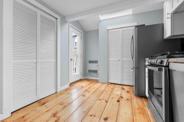 80 Lennox Rd Unit 1, Nahant, MA 01908 - kitchen with stainless steel range, lofted ceiling, light wood finished floors, heating unit, and baseboards