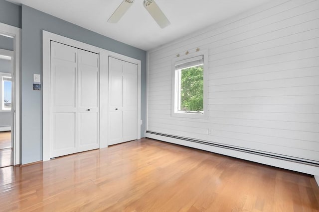 80 Lennox Rd Unit 1, Nahant, MA 01908 - unfurnished bedroom with a baseboard heating unit, light wood-type flooring, a ceiling fan, and multiple closets