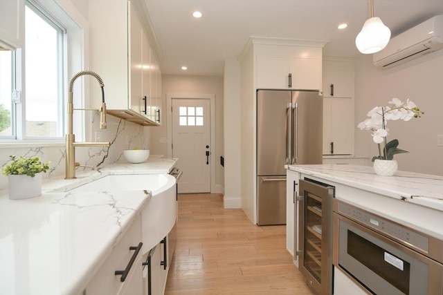 57 Garrison Ave Unit 57, Somerville, MA 02144 - kitchen with a wall mounted AC, stainless steel appliances, beverage cooler, light wood-type flooring, and recessed lighting